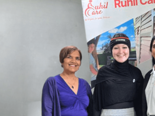 three women standing next to a sign